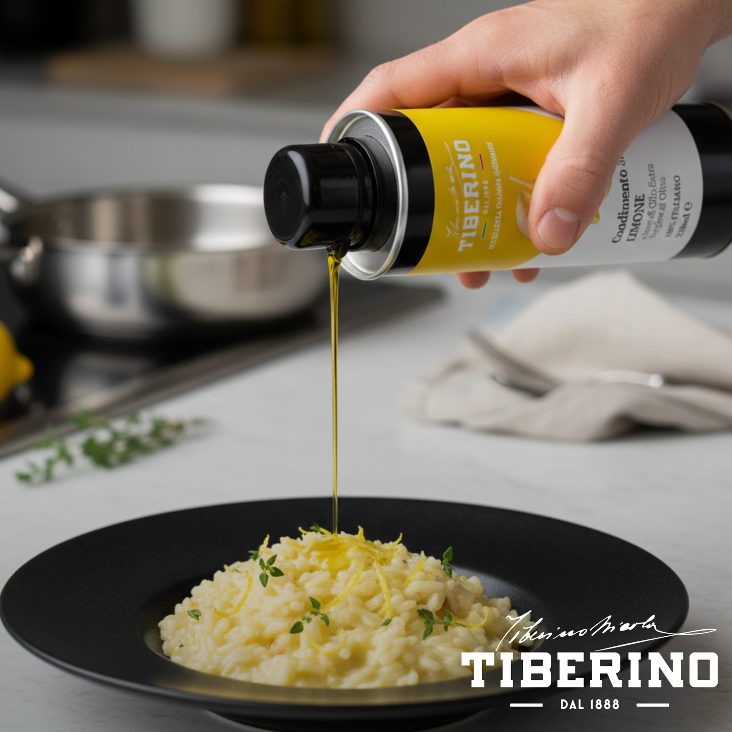 Mano versa Condimento al Limone Tiberino 1888 da lattina gialla e nera su risotto bianco con scorze di limone e timo in piatto nero.