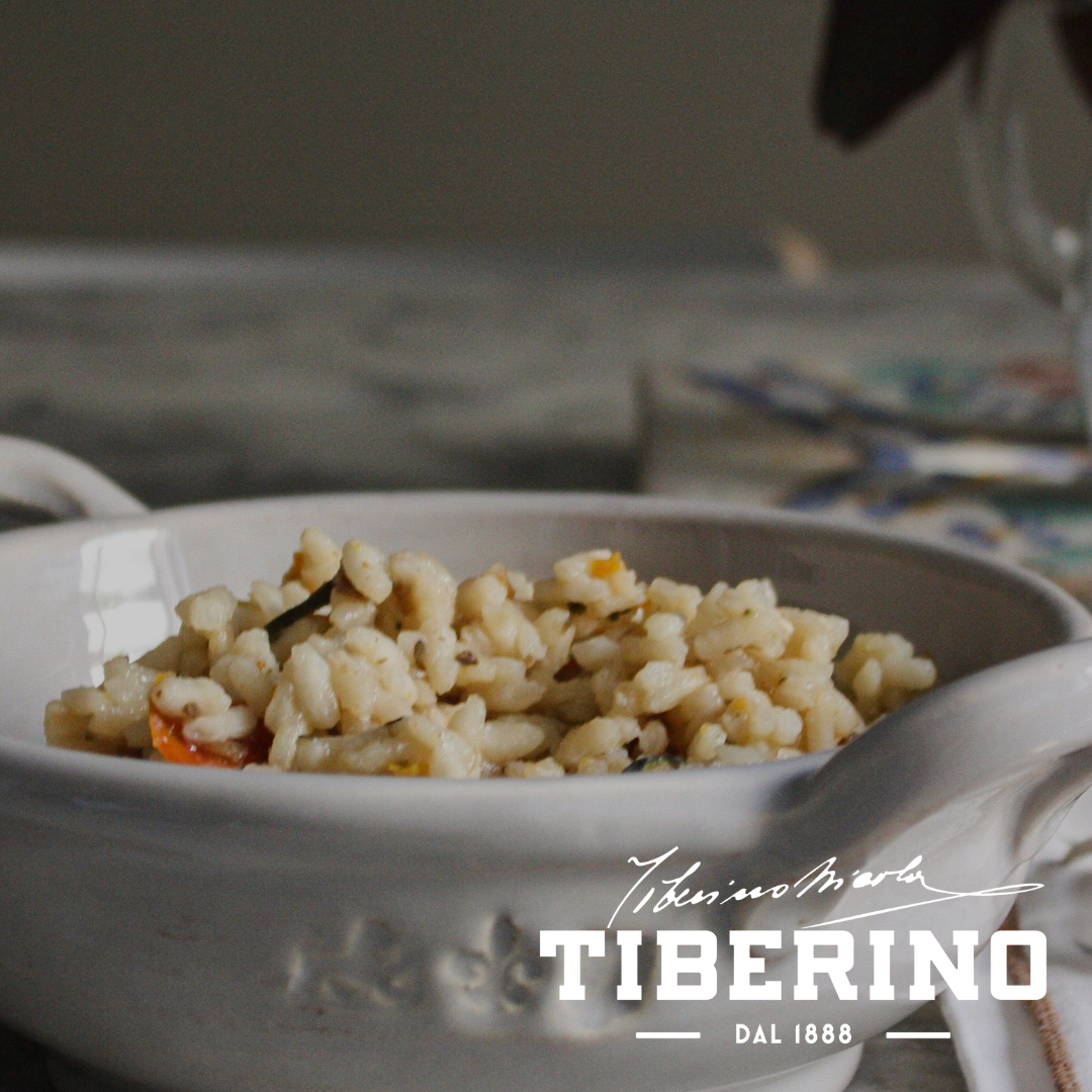 Risotto all’Ortolana con verdure e lenticchie rosse in ciotola di ceramica bianca, logo Tiberino 1888.