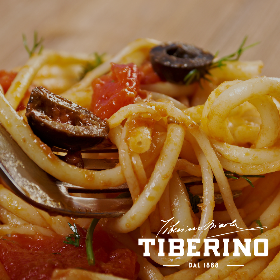 Forchetta d'argento con linguine alla puttanesca, pomodoro rosso a cubetti, olive nere e capperi verdi.