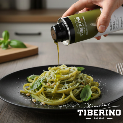Mano versa condimento all'aglio Tiberino 1888 da lattina verde 250ml su pasta al pesto con pinoli e basilico.