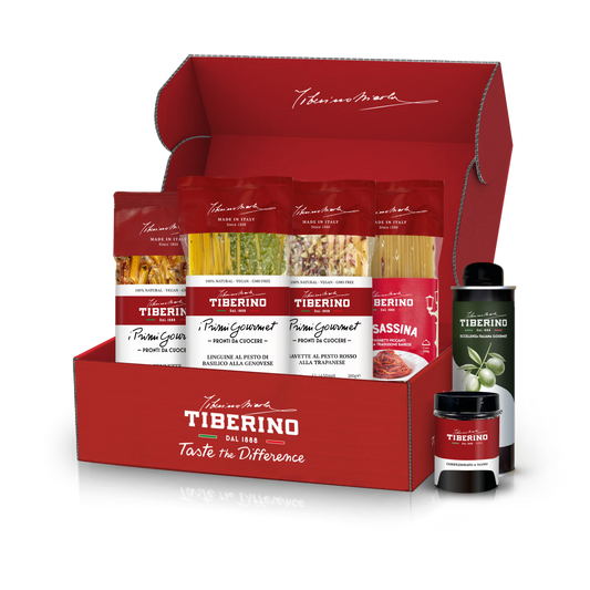 Cofanetto regalo rosso Tiberino 1888 con cinque pacchi di pasta, una bottiglia di olio d'oliva e un vasetto di salsa.