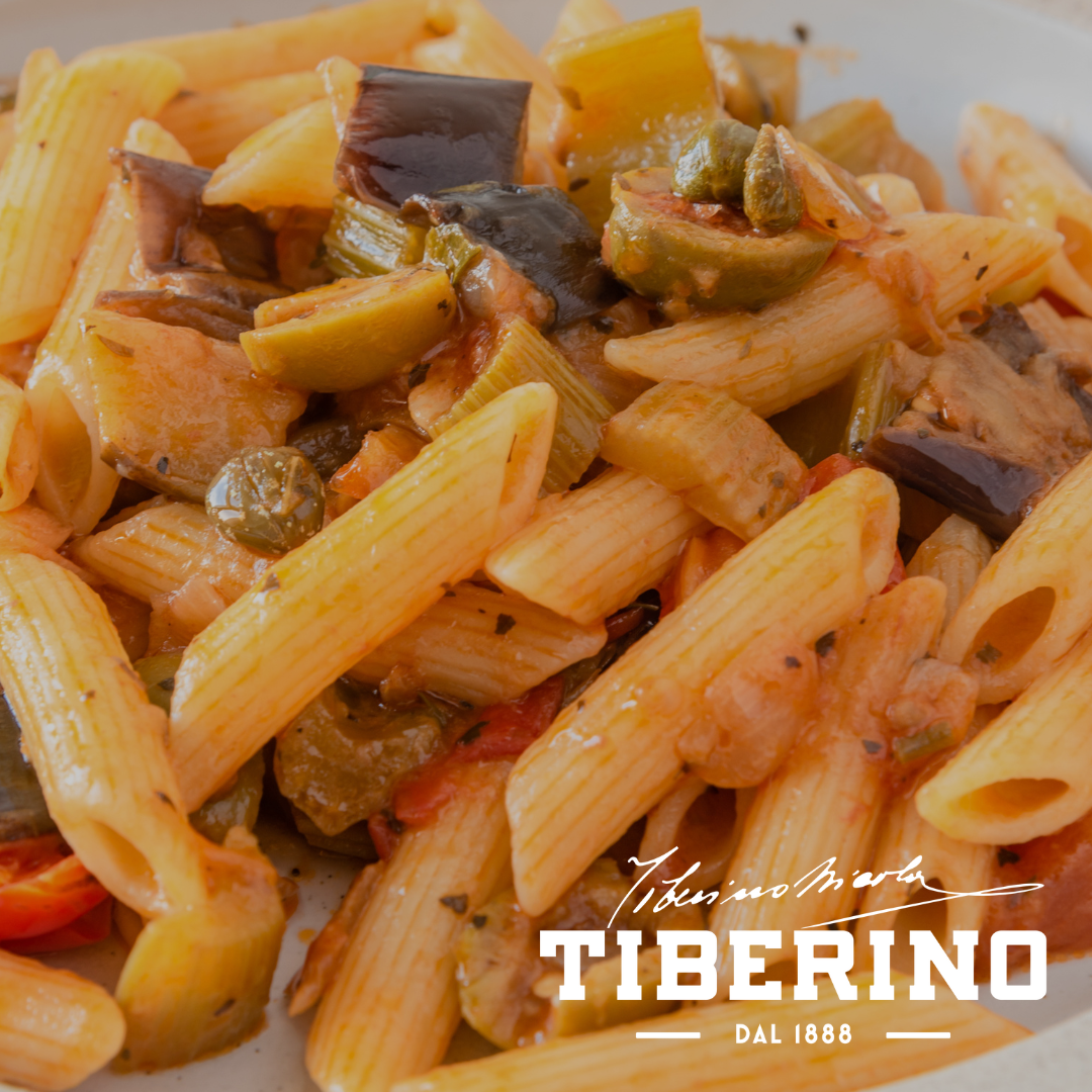 Pennette con melanzane viola, peperoni rossi, olive verdi e capperi in salsa di pomodoro.