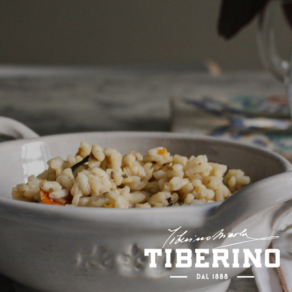 Risotto all’Ortolana con verdure e lenticchie rosse in ciotola di ceramica bianca, logo Tiberino 1888.