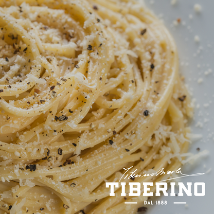 Spaghetti "Cacio e pepe" vegani con pepe nero macinato e formaggio grattugiato, marchio Tiberino Dal 1888.