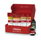 Scatola regalo rossa aperta di Tiberino 1888 con quattro confezioni di pasta vegana, una bottiglia di olio d'oliva e un vasetto.